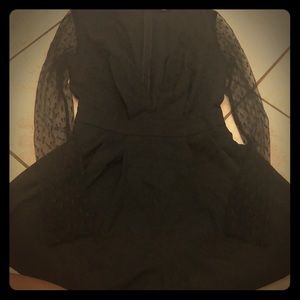 Black romper, mesh long sleeves and deep V detail